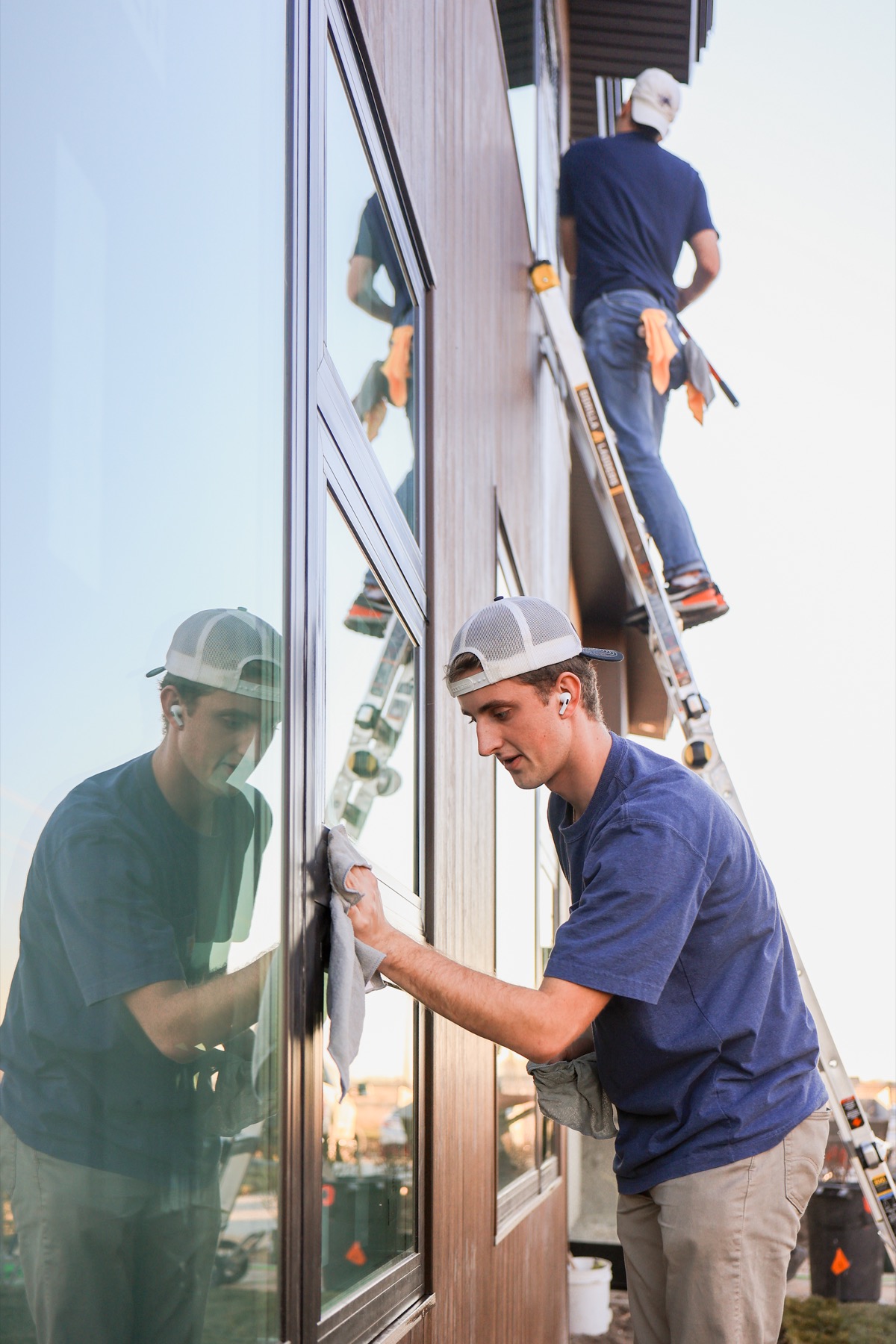 Summit Solutions cleaning exterior windows from a ladder
